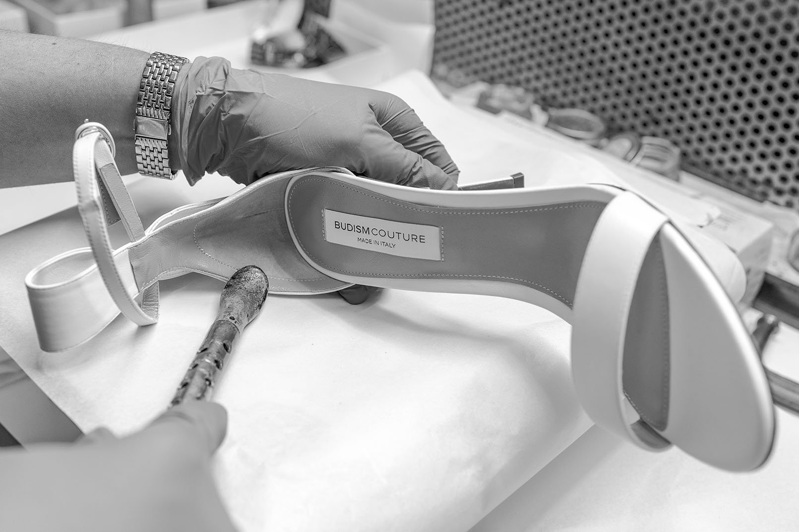 Person wearing gloves applying finishing touches to a BUDISM COUTURE high heel